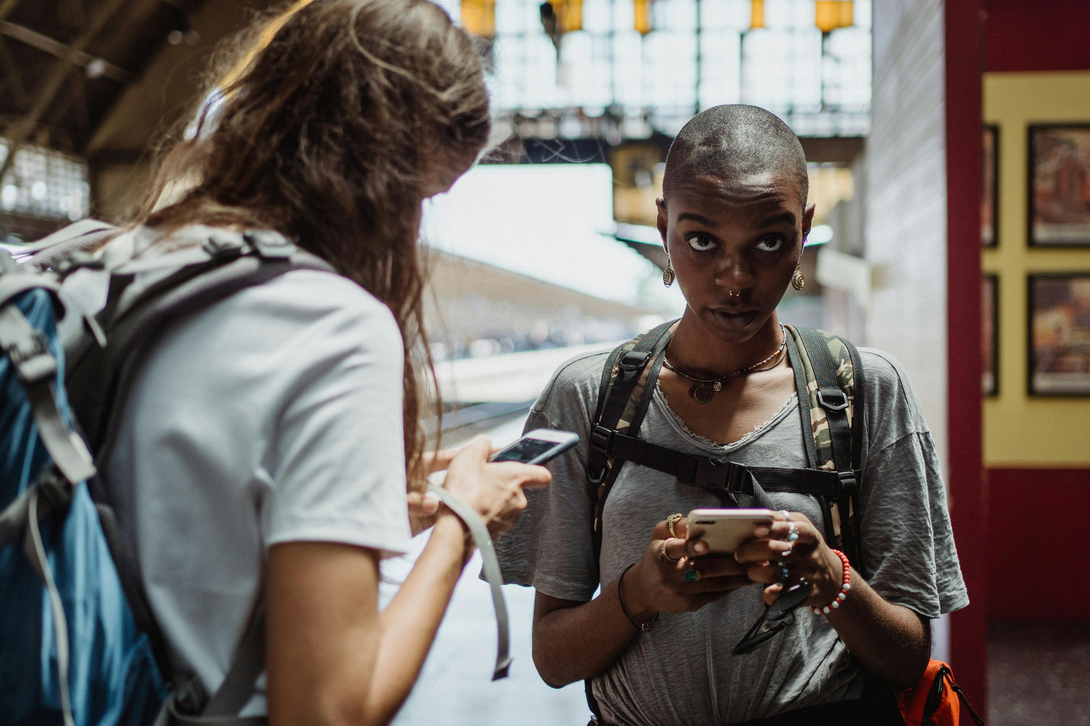 Young adults using their phones on the go.